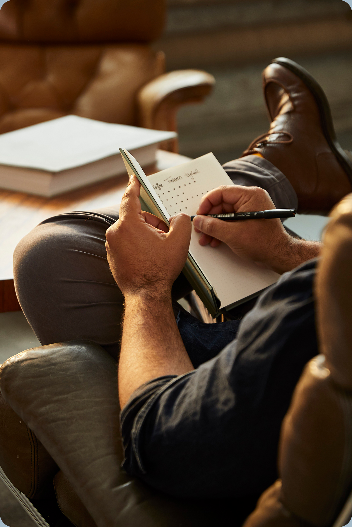Mann schreibt in Bullet Journal